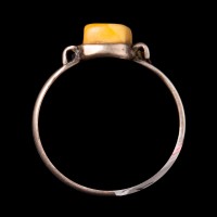 Srebrny pierścionek z żółtym kamieniem.